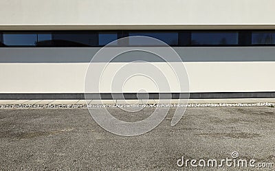 Concrete sidewalk with decorative gravel between a modern white building and the urban street Stock Photo