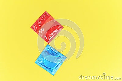 Condom isolated on yellow background / Colorful condom pack for birth control contraceptive means prevent pregnancy or sexually Stock Photo