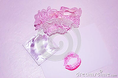 Garters, kiss and condom on white background Stock Photo