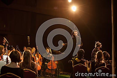 Conductor directs the performance in light of the spotlight Editorial Stock Photo