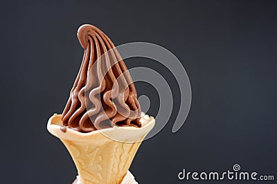 A cone of soft chocolate ice cream on dark background with copy space Stock Photo