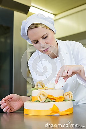 Confectioner, baker or pastry cook preparing cake Stock Photo