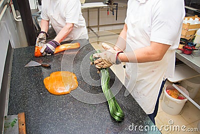 Confectioners making candies from melted sugar in candy workshop Stock Photo
