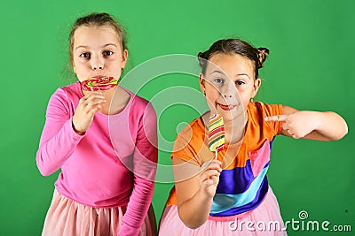 Confectionery and childhood concept. Girls eat big colorful sweet caramels Stock Photo