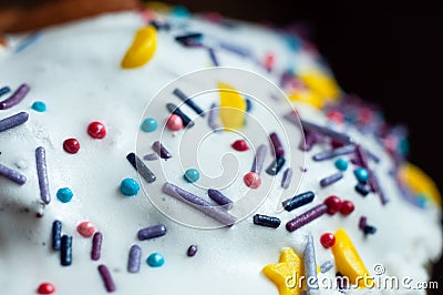 Confectionery sweet topping on a white glaze. Blue and red balls, Purple sticks. Yellow slices, macro shot Stock Photo