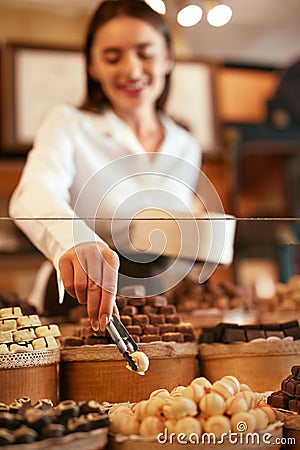 Confectionery. Woman Selling Chocolate Candies In Store Stock Photo