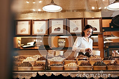 Confectionery. Woman Selling Chocolate Candies In Store Stock Photo