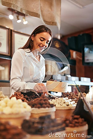 Confectionery. Woman Selling Chocolate Candies In Store Stock Photo