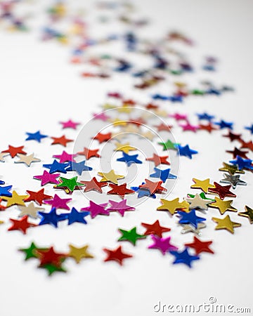 Confetti stars on white background, festive colorful and shiny stars on white background with copy space Stock Photo