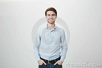 Confidence and business concept. Portrait of charming successful young entrepreneur in blue-collar shirt, smiling Stock Photo