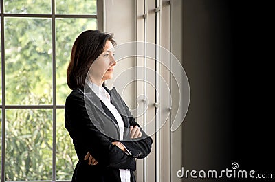 Confidence Caucasian businesswoman crossed her arms and looking out the window Stock Photo