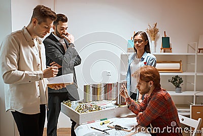 Confident ambitious serious team of engineers working together in studio. Stock Photo
