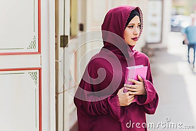 Confident Arab businessman smiling and walks of Dubai. Arab Business vumen hijab is in the streets against the Stock Photo