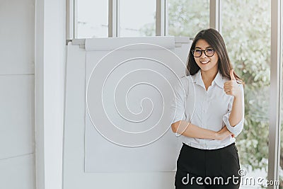 Confident Asian woman with blank flipchart Stock Photo