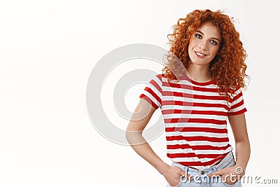 Confident assertive gorgeous curly-haired redhead woman hold hands pockets self-assured smiling tilting head wearing Stock Photo