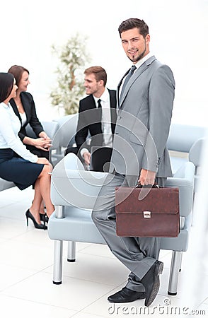 Confident businessman with briefcase standing in the lobby of the office. Stock Photo