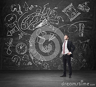 A confident businessman in formal suit is thinking about business development. A sketched brainstorm process is drawn on the huge Stock Photo