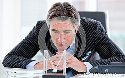 Confident businessman looking at kinetic balls Stock Photo