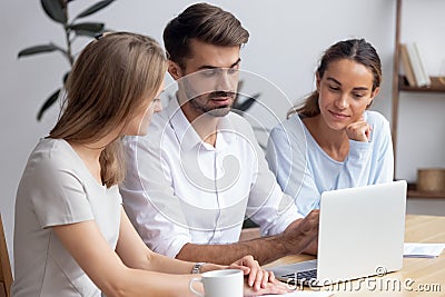 Confident businessman, mentor helping trainees with new software, staff training Stock Photo