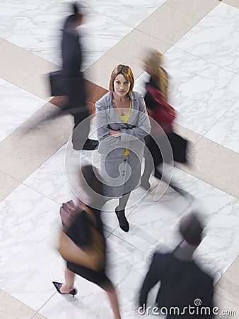 Confident Businesswoman Amid Blurred Walking People Stock Photo