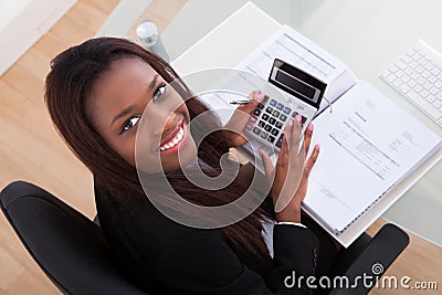 Confident businesswoman calculating tax at desk Stock Photo