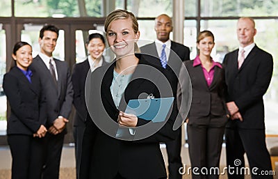 Confident businesswoman in front of co-workers Stock Photo