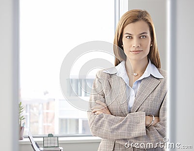 Confident businesswoman smiling in bright office Stock Photo