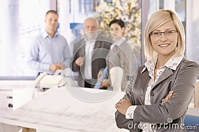 Confident businesswoman with team Stock Photo