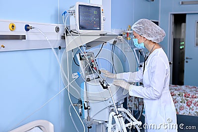 Confident Female Doctor Setting Up Medical Equipment Device For Treating Patient Stock Photo