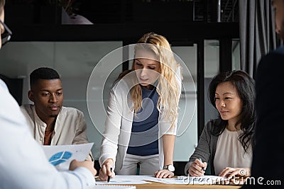 Confident businesswoman lead meeting with diverse colleagues in office Stock Photo