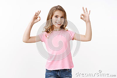 Confident cheerful cute smart little girl assure everything ok, smiling satisfied, approve cool online school, judging Stock Photo