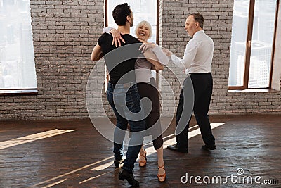 Confident dance instructor teaching aged people waltz in the ballroom Stock Photo