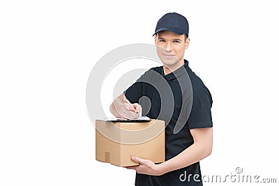 Confident deliveryman at work. Cheerful young deliveryman holding a cardboard box with a clipboard on it and smiling while Stock Photo