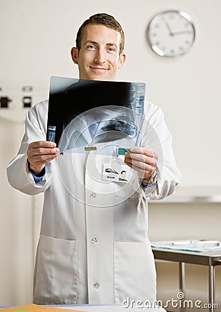 Confident doctor in lab coat examining x-ray Stock Photo