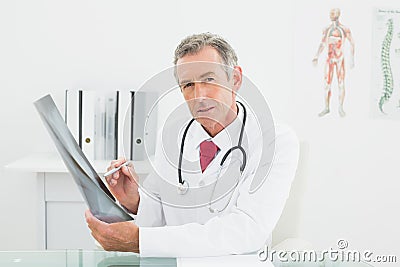 Confident doctor with xray picture of lungs in office Stock Photo