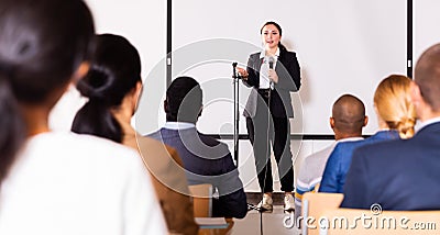 Confident female lecturer speaking to businesspeople at seminar Stock Photo
