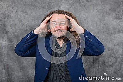 Confident gentleman with long hair striking different standing postures in stylish blue suit Stock Photo