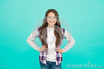 Confident in her style. happy small girl turquoise background. cheerful schoolgirl has long curly hair. child wear Stock Photo