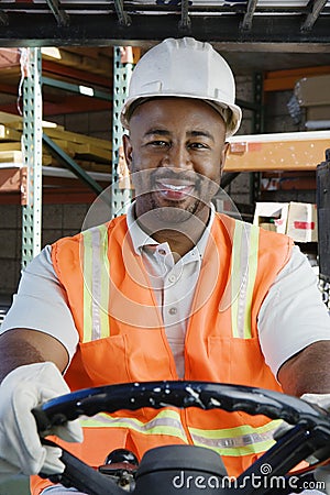 Confident Industrial Worker Driving Forklift At Workplace Stock Photo