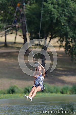 Confident joyful woman climbing in rope park Stock Photo