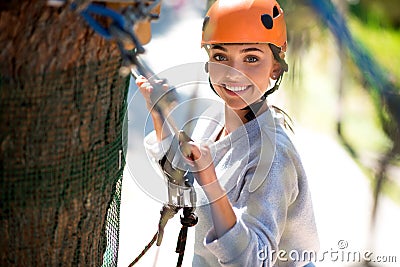 Confident joyful woman climbing in the rope park Stock Photo