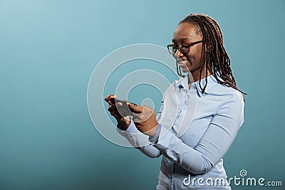 Confident joyful young adult person with modern cellphone watching video content. Stock Photo