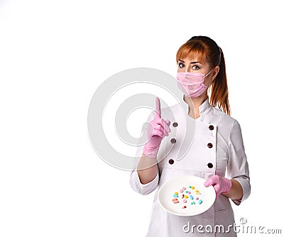 Confident lady doctor in medical mask holding plate with pills in assortment pointing index finger up. Waist-up shot isolated on Stock Photo
