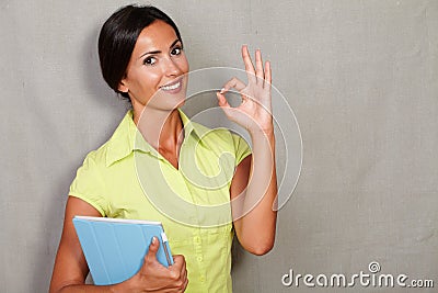 Confident lady showing ok sign and holding tablet Stock Photo