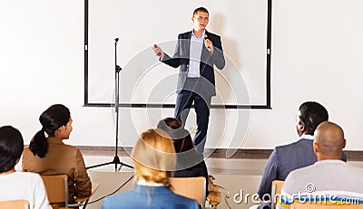 Confident lecturer speaking to businesspeople at seminar Stock Photo