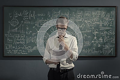 Confident math professor teaching in front of the chalkboard Stock Photo