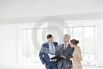 Confident mature business discussing over document with young colleagues at new office Stock Photo