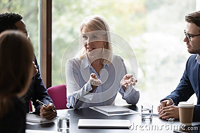 Confident middle-aged businesswoman head meeting with coworkers Stock Photo