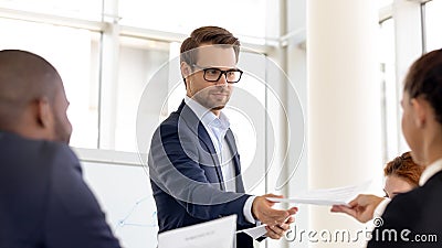 Male presenter share handout materials to employees at meeting Stock Photo