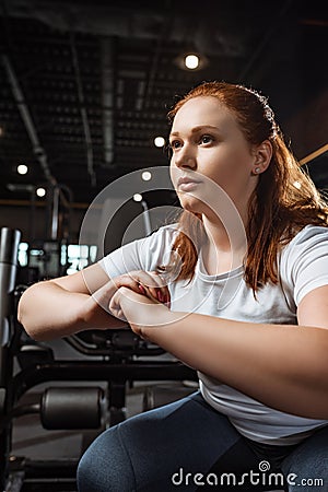 Confident overweight girl squatting with clenched hands Stock Photo